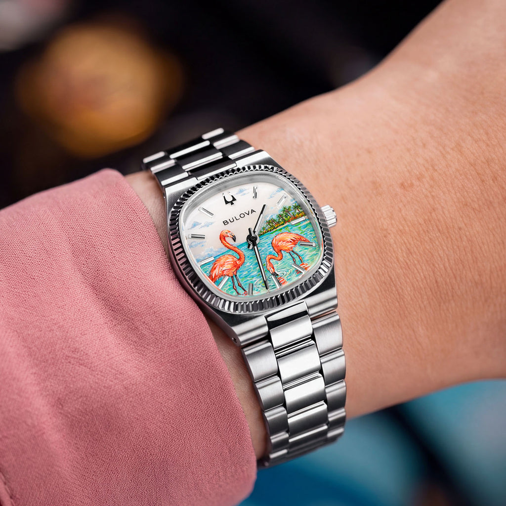 Bulova Super Seville Mini Havana — Custom hand-painted dial seen at the wrist, one flamingo bending to feed among ripples between silver baton markers, a bespoke timepiece by IFL Watches.