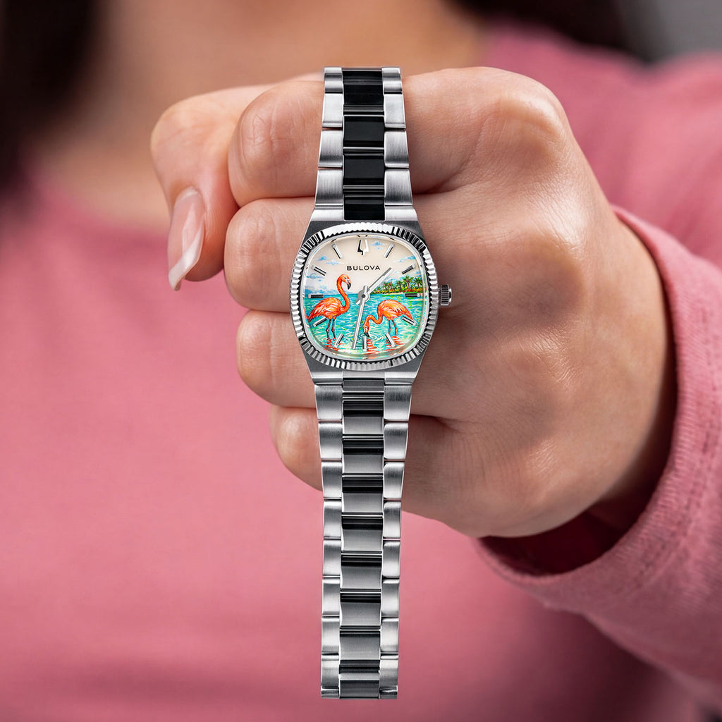 Bulova Super Seville Mini Havana — Held up in a closed hand, the 25mm watch reveals its hand-painted custom dial of coral flamingos in turquoise shallows on a stainless steel bracelet, a bespoke timepiece by IFL Watches.