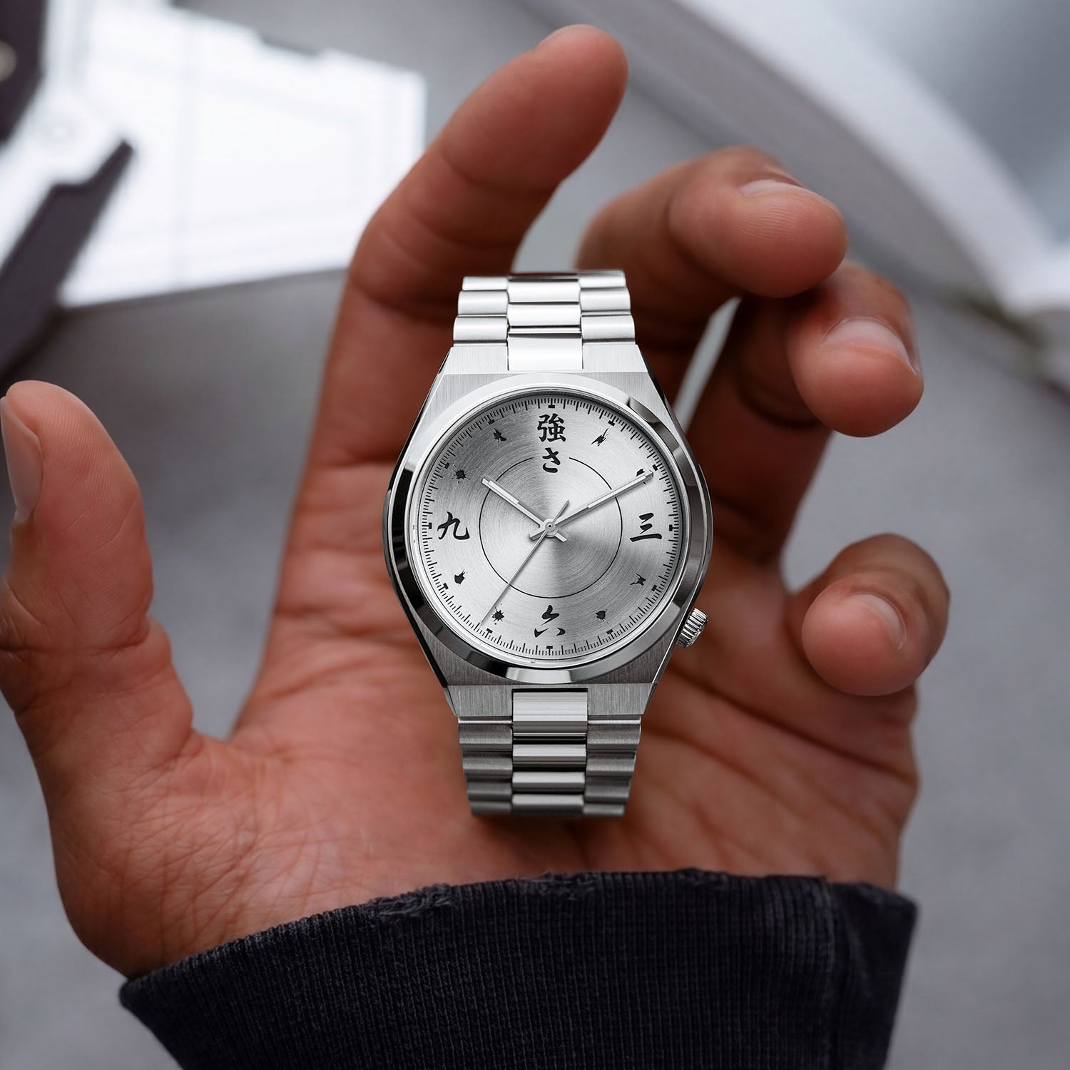 Citizen Tsuyosa Kanji held in hand — full view of twelve Kanji characters and small symbols between the hours on a brushed silver dial, stainless steel case and integrated bracelet, a custom timepiece by IFL Watches.