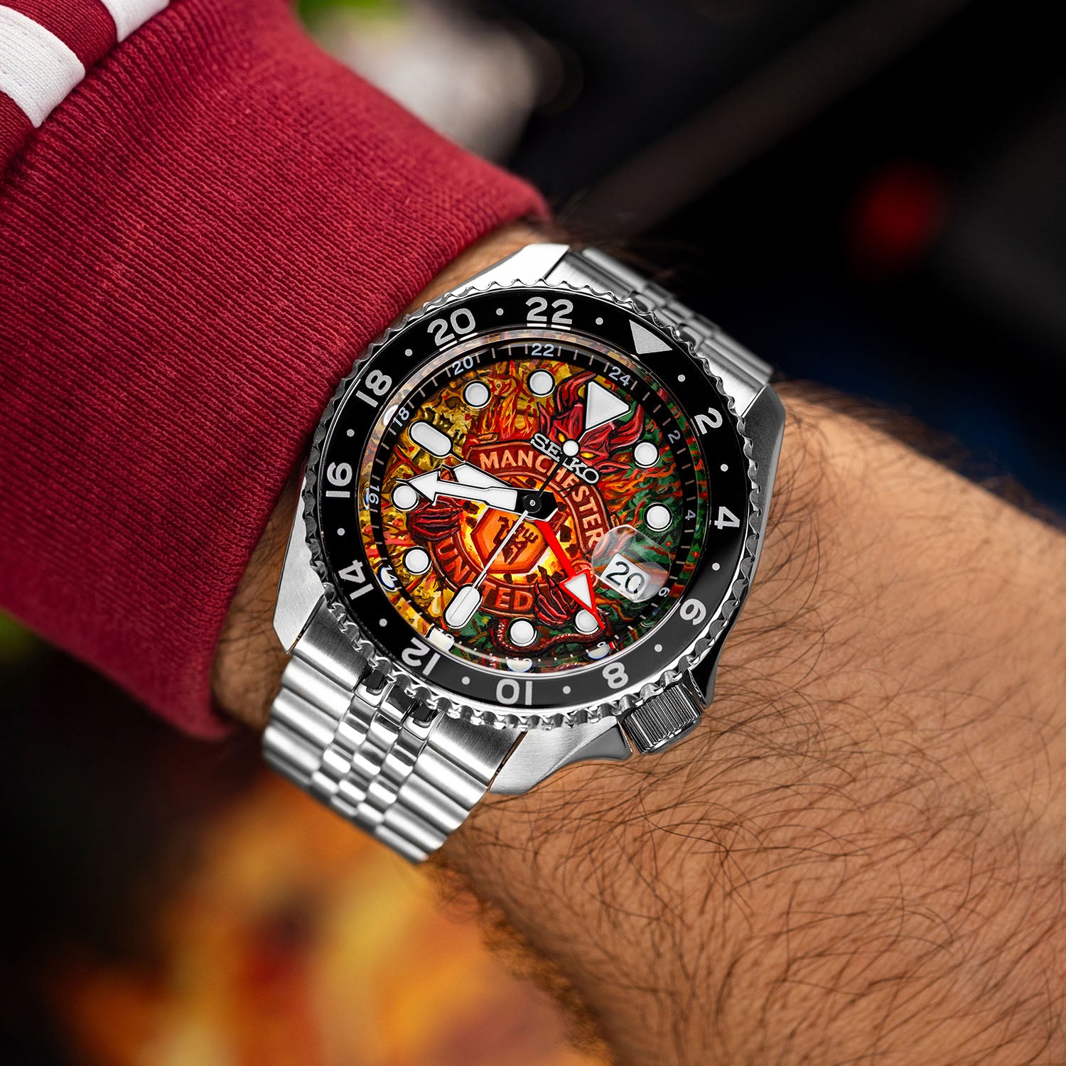 The Red Devils Concept on wrist — top-down view of the hand-painted football crest engulfed in flames on a 42.5mm stainless steel case with black 24-hour GMT bezel, a bespoke timepiece by IFL Watches.