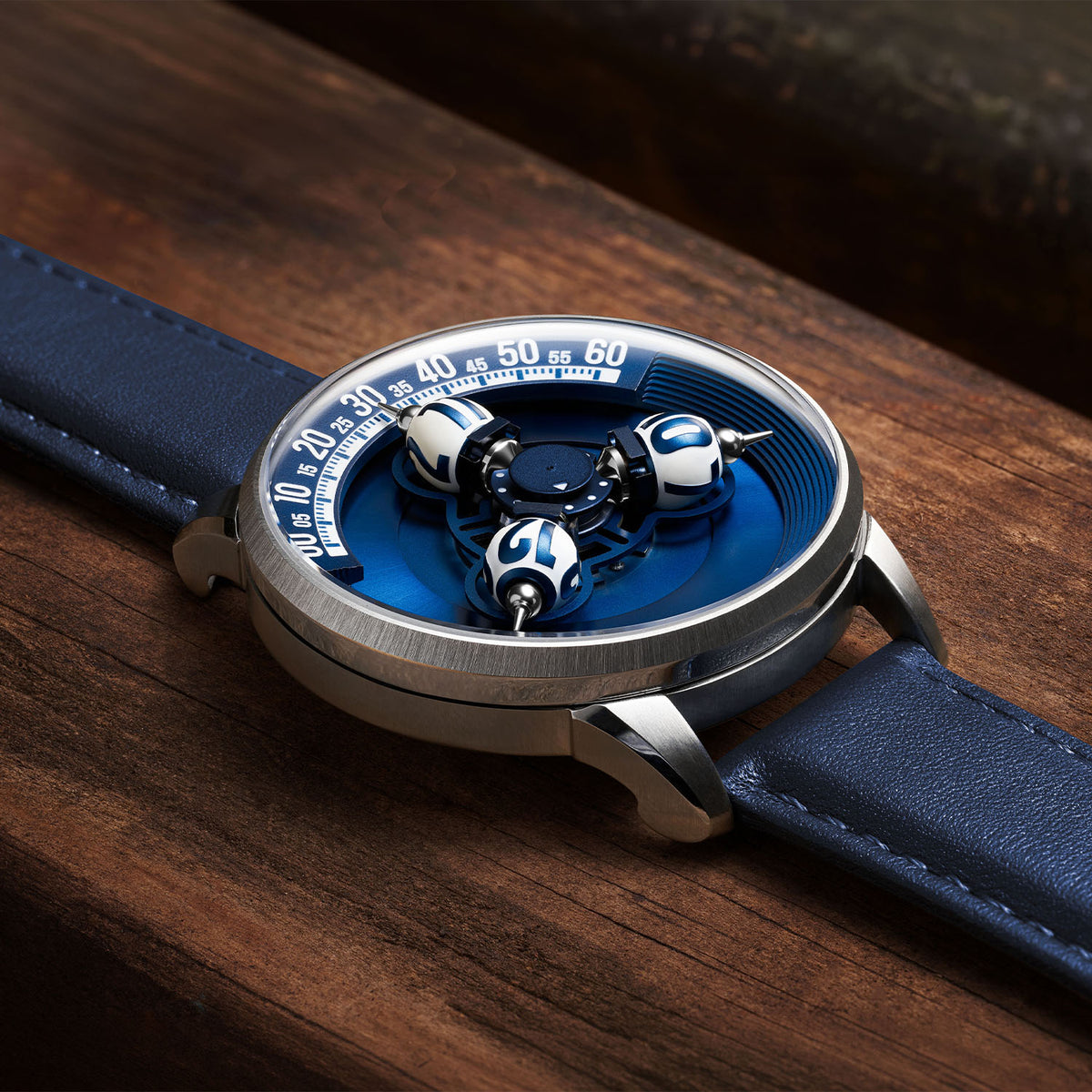 Vortichron Timeorb Blue — Low side view on wood, showing the case profile and raised spheres under sapphire crystal, available at IFL Watches.